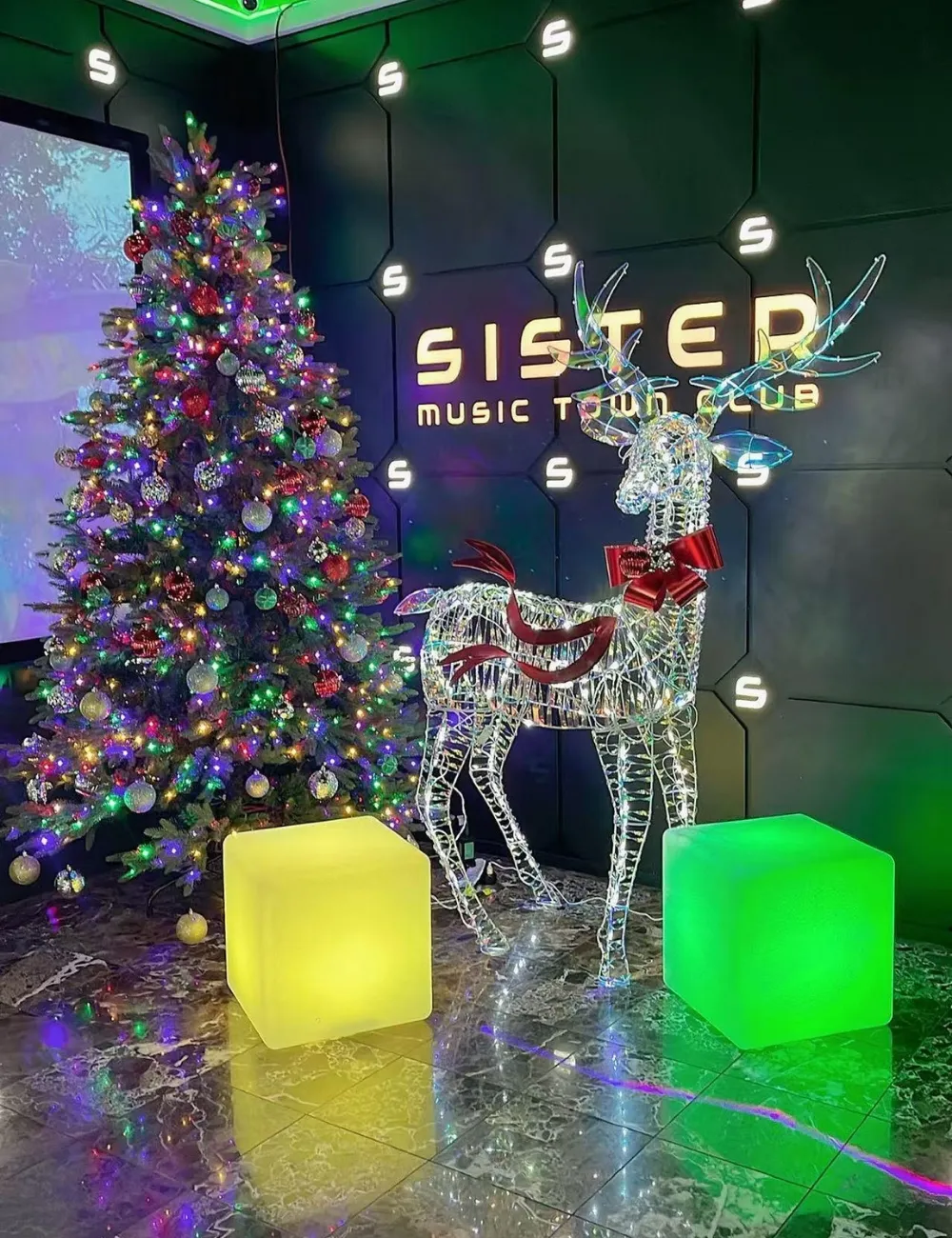 Lobby interior with Christmas tree and lighted reindeer at Sister Karaoke, a Karaoke bar in Buena Park